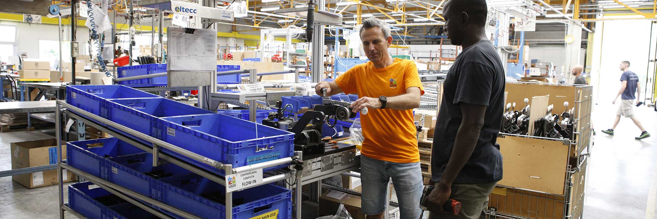 Un operatore spiega il lavoro da eseguire ad una persona in inserimento lavorativo