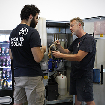 Persona in inserimento lavorativo impara i caricamenti dei distributori di caffè