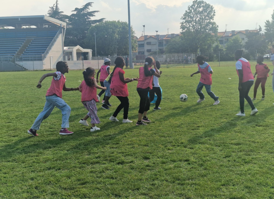 Bambini e ragazzi giocano a calcio in campo aperto durante il torneo della festa finale del doposcuola SSEM.