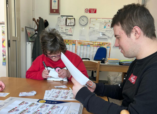 Due giovani con disabilità della UET Il Casale della cooperativa Il Piccolo Principe stanno preparando i materiale per i bambini della scuola dell'infanzia presso cui prestano servizio