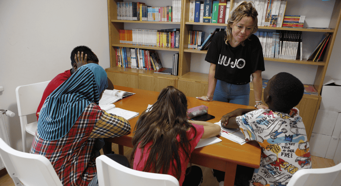 Educatrice del doposcuola Ssem con un gruppo di bambini impegnati nei compiti a Casarsa della Delizia