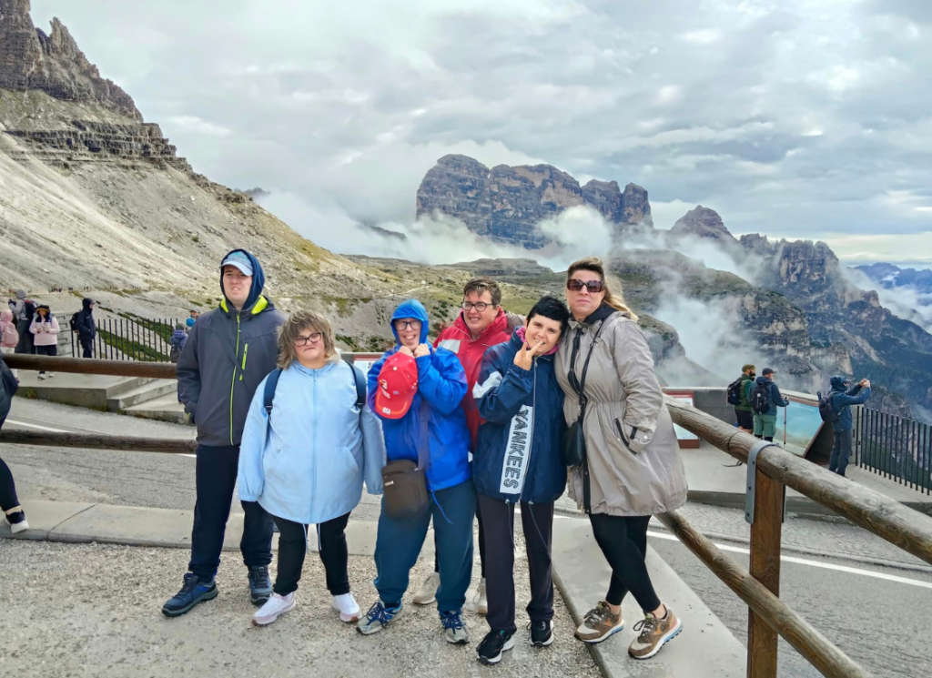 Foto di gruppo dei partecipanti alla vacanza della UET «Il Casale» durante l’escursione alle Tre Cime di Lavaredo, con le montagne sullo sfondo.